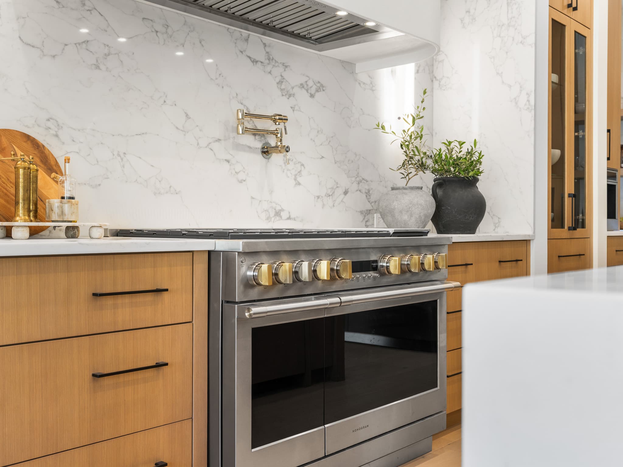Marble slab backsplash and a professional range in a custom kitchen remodel by Portland Tile in Portland, OR
