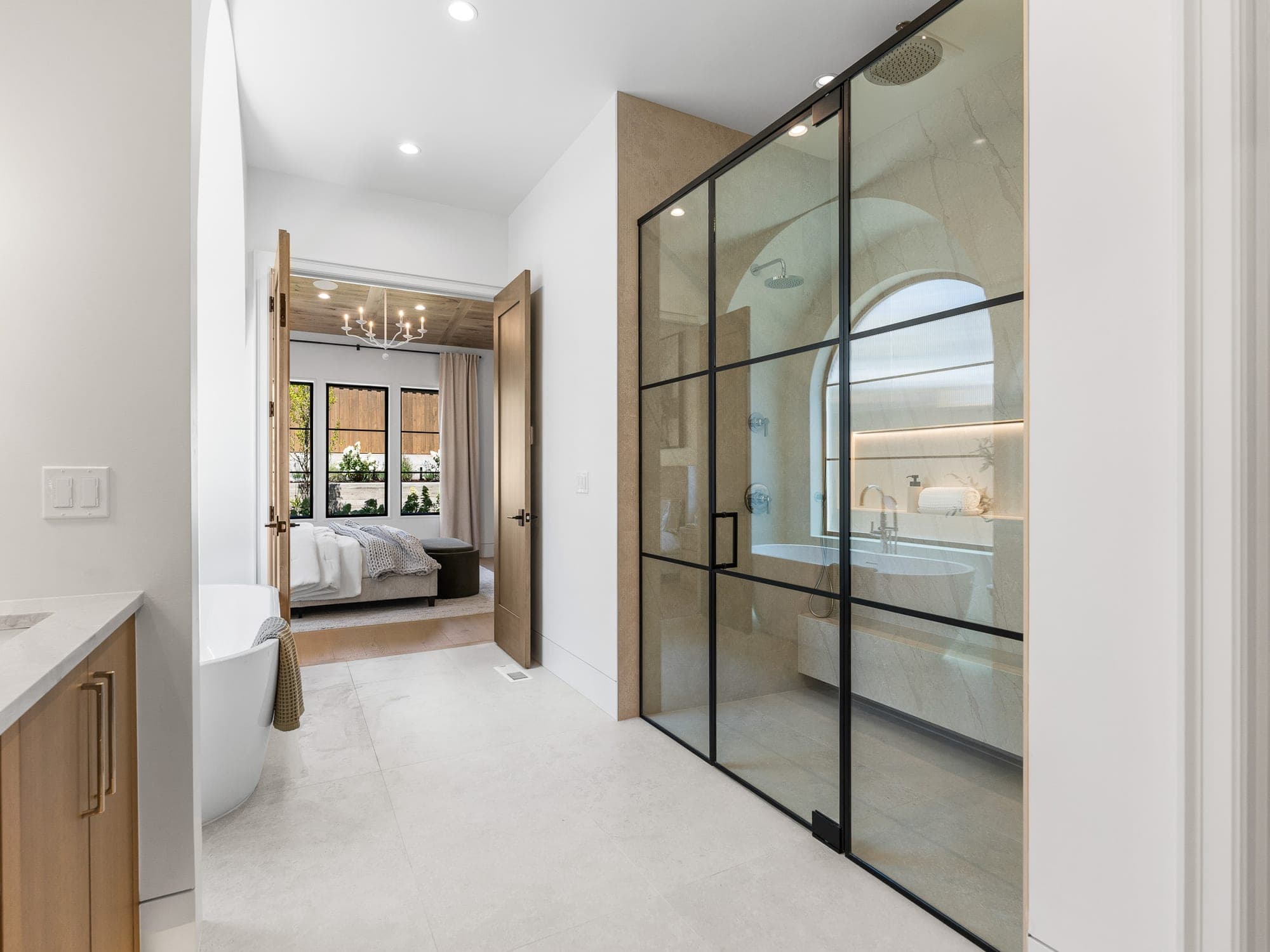 Custom black metal framed glass shower with quartz walls in a luxury primary suite in Happy Valley, OR