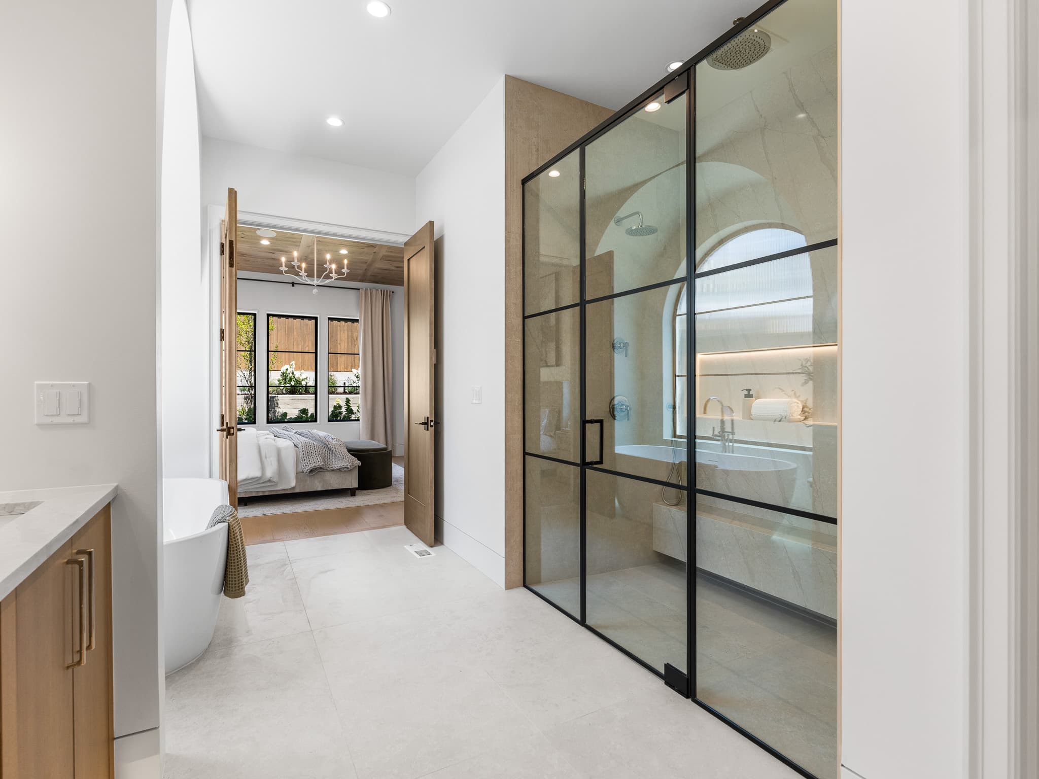 Custom black metal framed glass shower with quartz walls in a luxury primary suite by Portland Tile in Happy Valley, OR