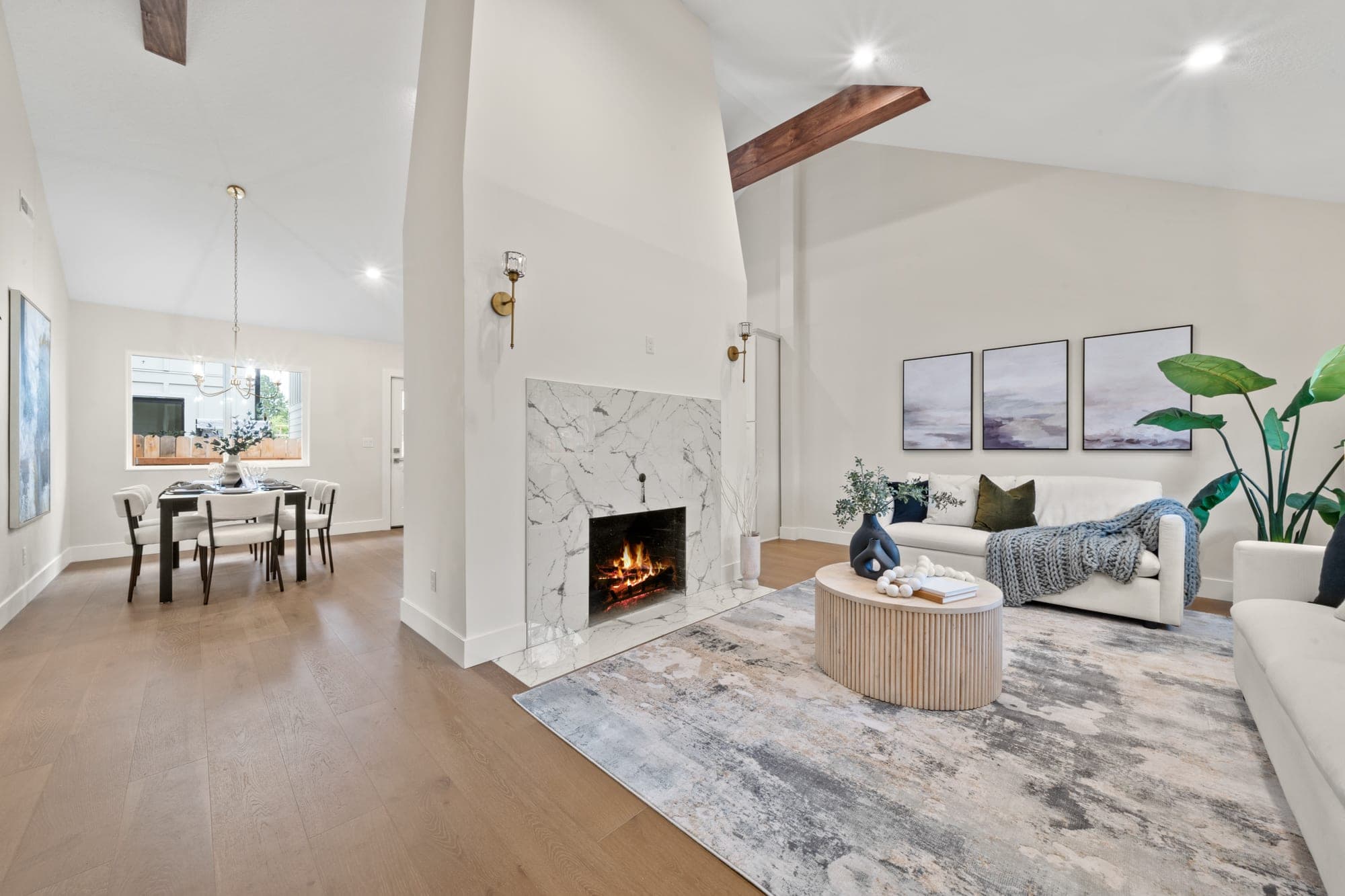 Living room of a remodeled 120 year old Craftsman with a marble fireplace, tile hearth, stained wood beams, and a raised vaulted ceiling in Southwest Portland, OR