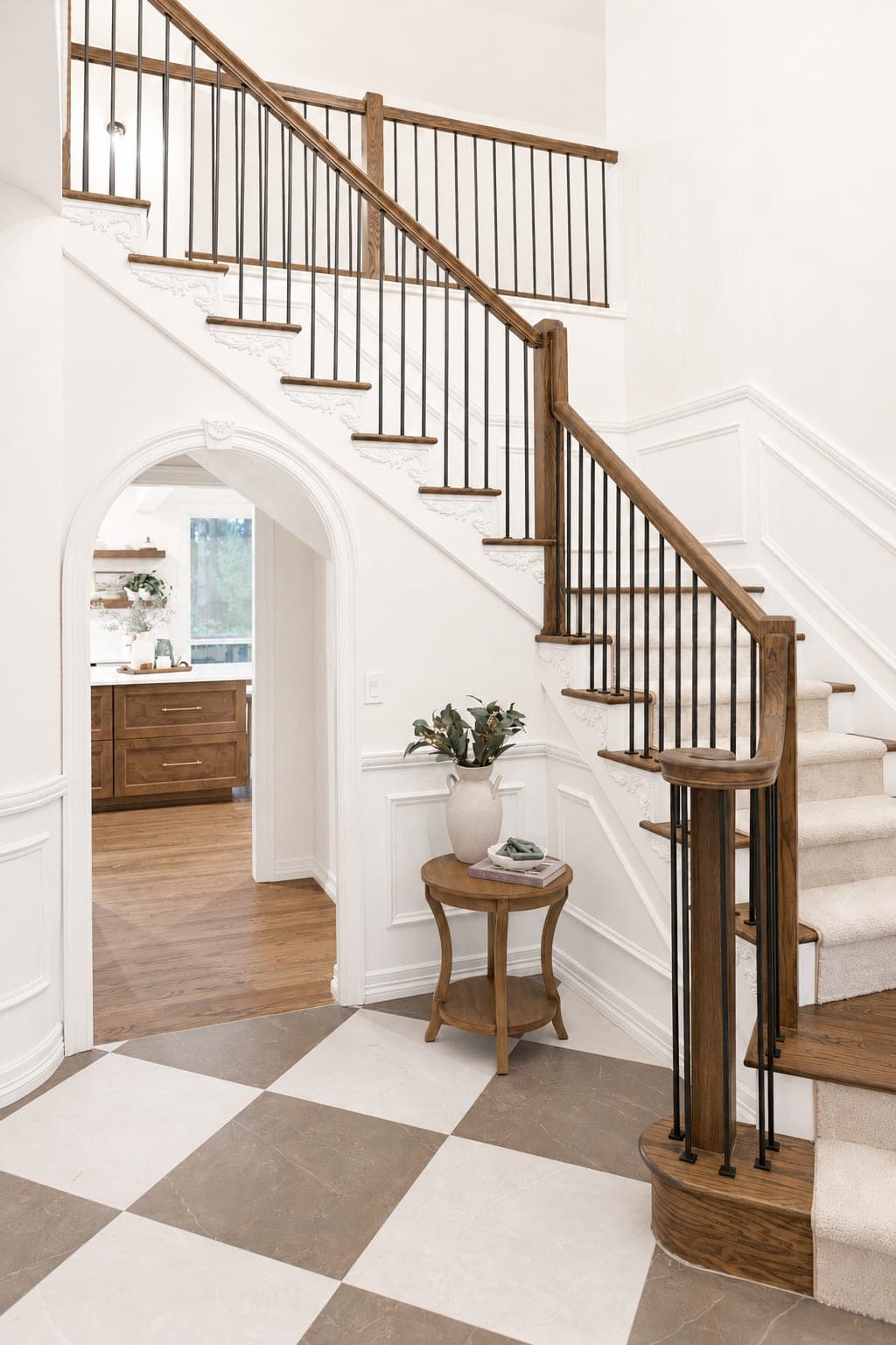 Entry foyer with a large format checkerboard tile floor, white wainscot, and an archway leading into the kitchen in Beaverton, OR