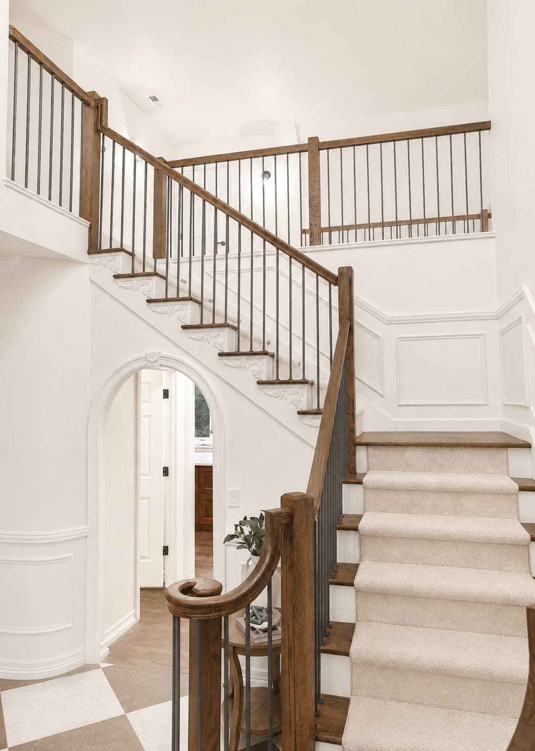 Staircase with solid hardwood treads, a patterned carpet runner, black metal spindles, and a stained wood railing in Beaverton, OR