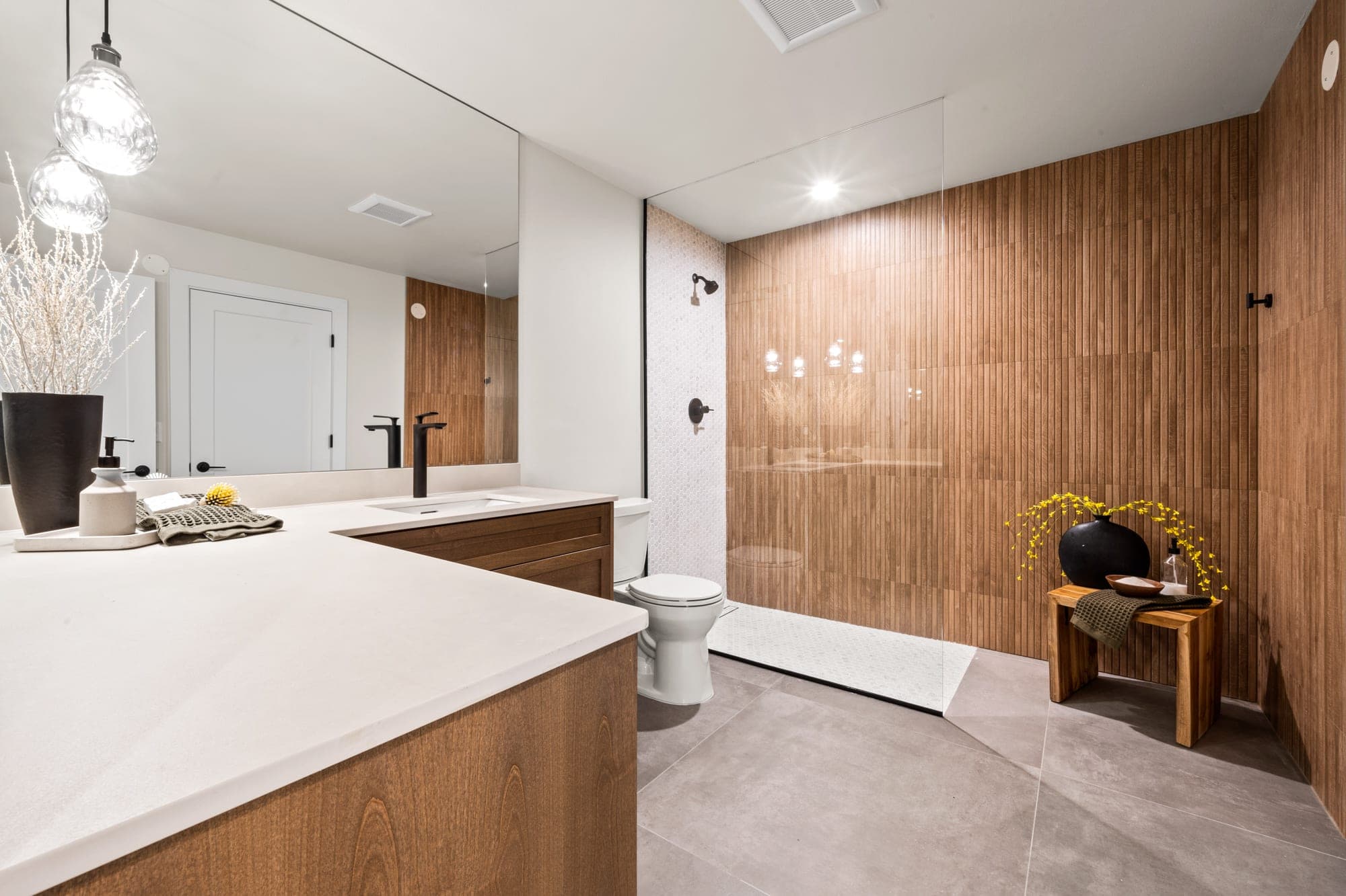 Curbless walk in shower with fluted wood look tile, frameless glass, and a mosaic pan in Government Camp, OR