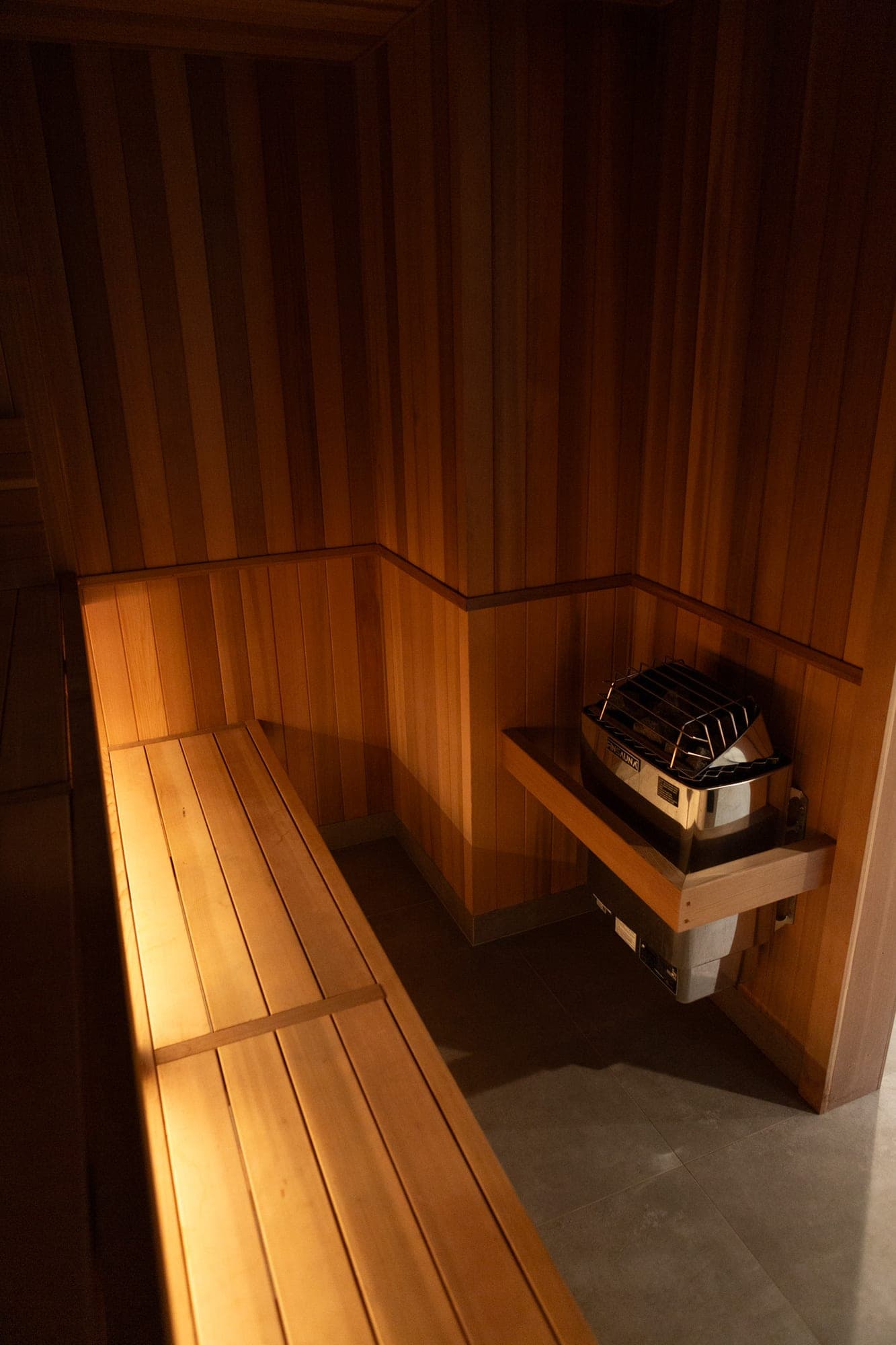 Custom cedar sauna with a FinSauna heater, tile floor, and lighting under the benches in Government Camp, OR
