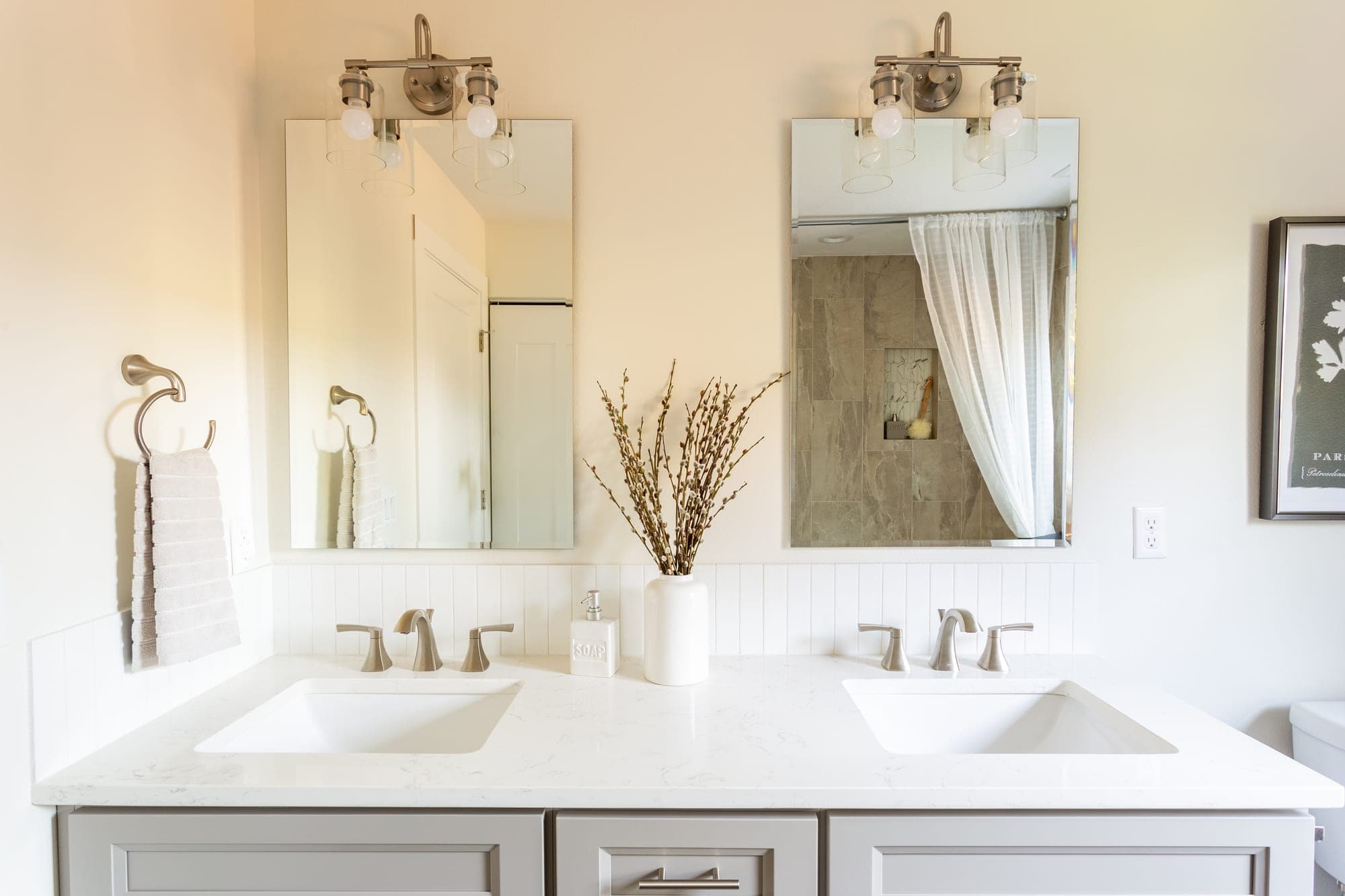 Bathroom with a double vanity, quartz countertop, and framed mirrors in Hillsboro, OR